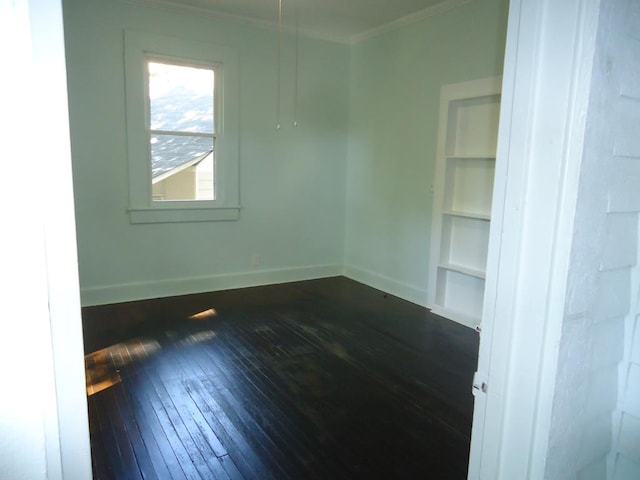 spare room with dark hardwood / wood-style flooring and ornamental molding