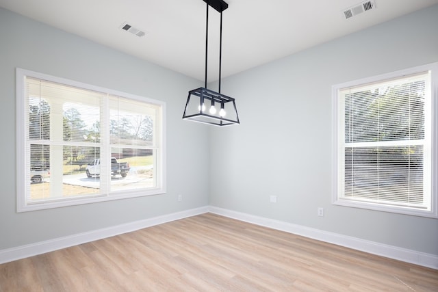 unfurnished dining area with visible vents, baseboards, and light wood-style flooring