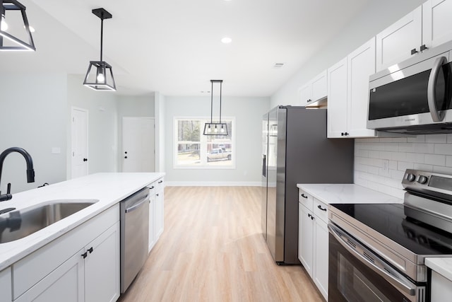 kitchen featuring white cabinetry, tasteful backsplash, appliances with stainless steel finishes, and a sink