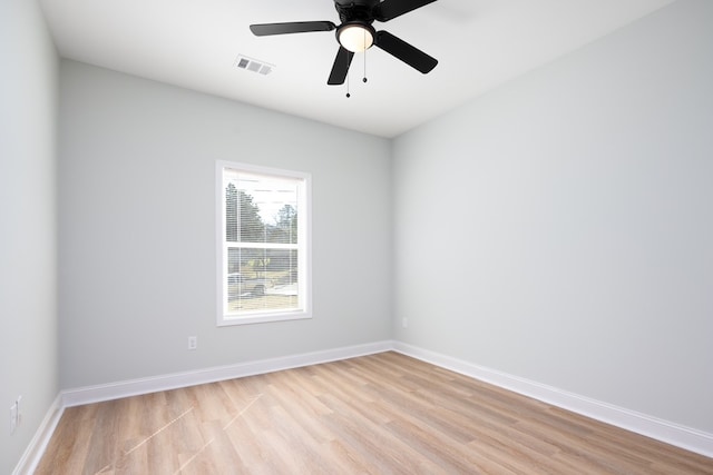 empty room featuring ceiling fan, light wood-style floors, visible vents, and baseboards