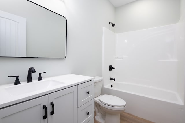 bathroom featuring vanity, wood finished floors, toilet, and tub / shower combination