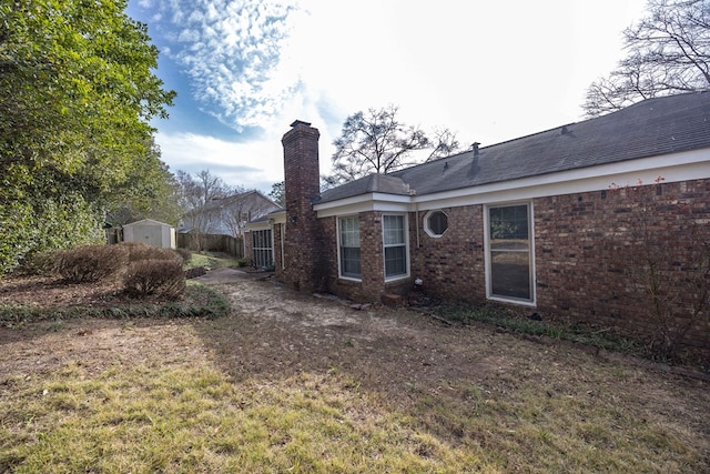 6138 Seaton Dr, Columbus, GA 31909 - rear view of house with a storage unit, a chimney, and brick siding