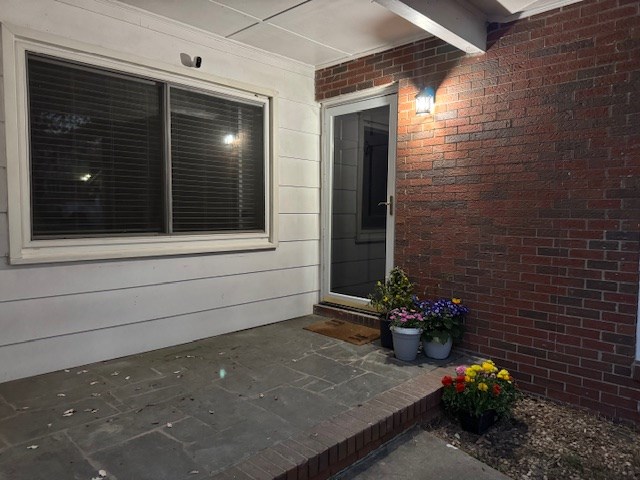 view of exterior entry featuring brick siding