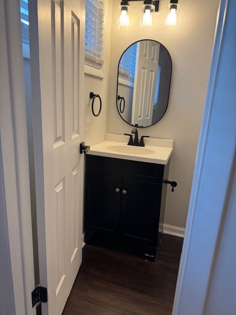 bathroom with vanity, baseboards, and wood finished floors