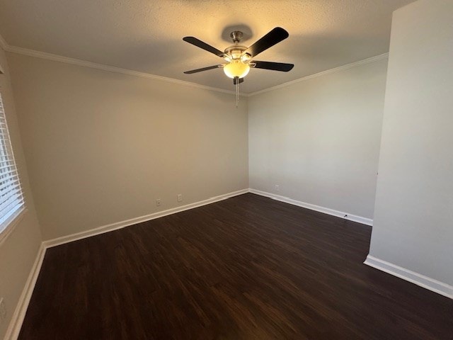 empty room featuring a ceiling fan, dark wood-type flooring, crown molding, and baseboards