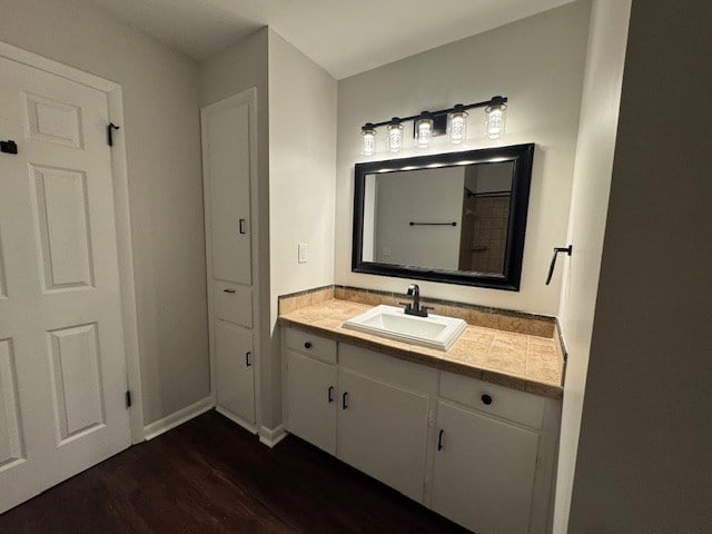 bathroom featuring baseboards, wood finished floors, and vanity