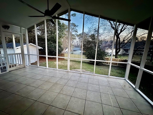 unfurnished sunroom featuring a ceiling fan