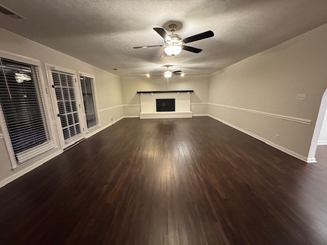 unfurnished living room with baseboards, ceiling fan, wood finished floors, a glass covered fireplace, and a textured ceiling