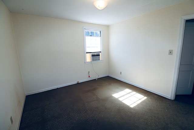 unfurnished room with cooling unit and dark colored carpet