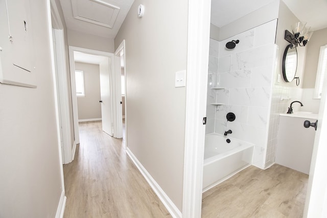 bathroom with wood finished floors, washtub / shower combination, and vanity