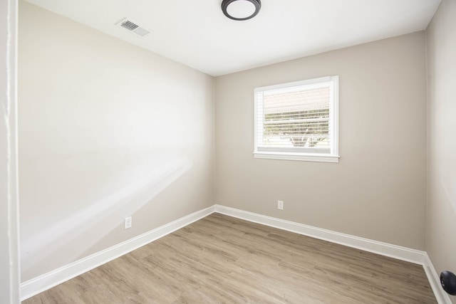 spare room featuring light wood-style flooring and baseboards