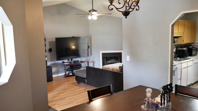908 Arlington Dr, Columbus, GA 31907 - dining area with ceiling fan, light wood-style flooring, high vaulted ceiling, a fireplace, and a chandelier