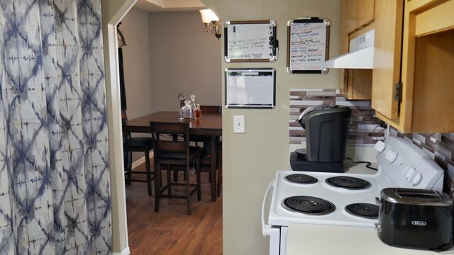 908 Arlington Dr, Columbus, GA 31907 - kitchen with white range with electric stovetop, under cabinet range hood, wood finished floors, and a chandelier