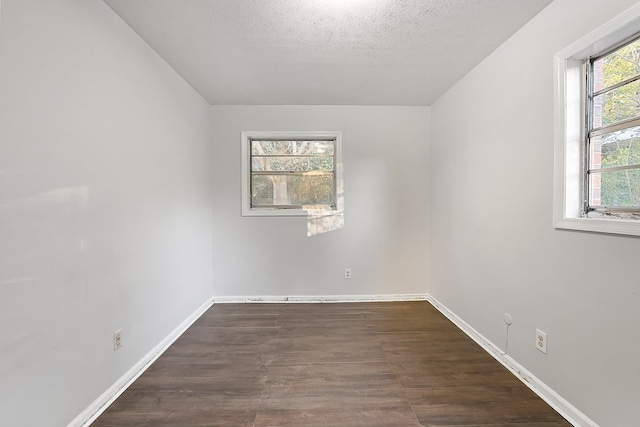 unfurnished room with a textured ceiling and dark hardwood / wood-style floors