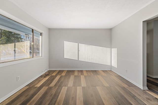 unfurnished room with a textured ceiling and dark wood-type flooring