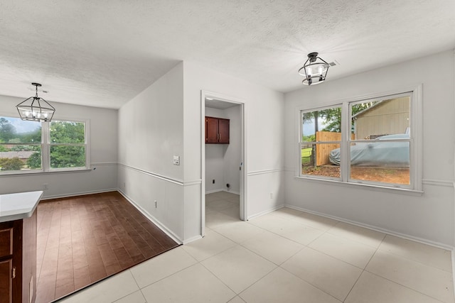 4658 Thoroughbred Ln, Columbus, GA 31909 - unfurnished dining area featuring a chandelier, plenty of natural light, a textured ceiling, and baseboards
