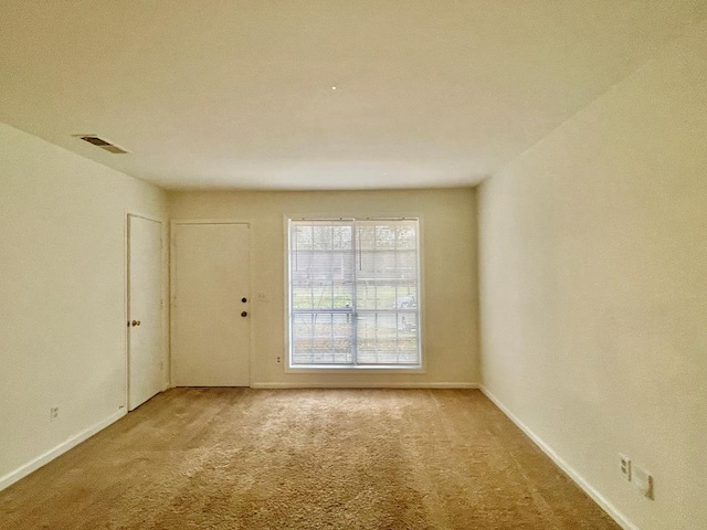 spare room with visible vents, baseboards, and carpet floors