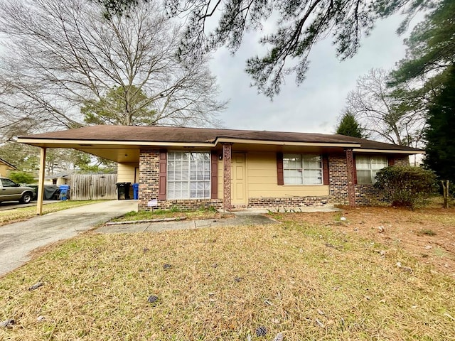 ranch-style home featuring an attached carport, fence, brick siding, and driveway