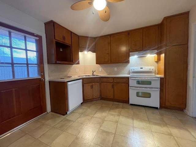 kitchen with ceiling fan, under cabinet range hood, light countertops, white appliances, and a sink