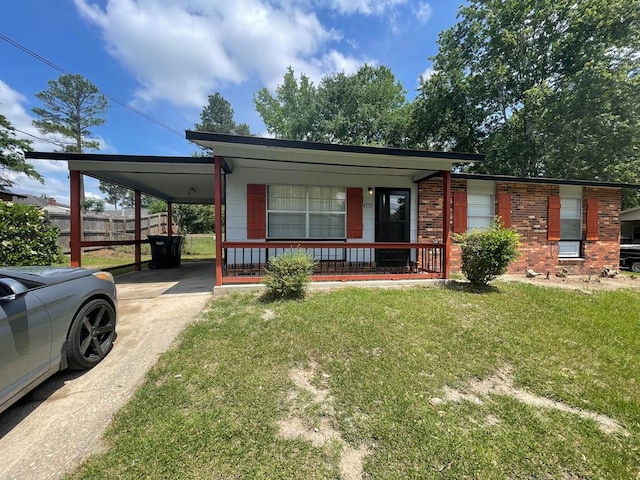 manufactured / mobile home with covered porch, fence, concrete driveway, a front yard, and a carport