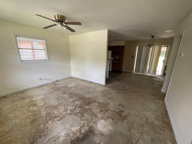 spare room featuring ceiling fan and baseboards