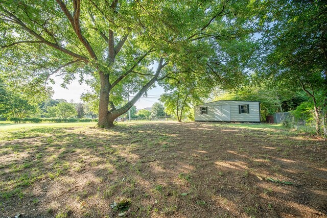 view of yard with an outbuilding and fence