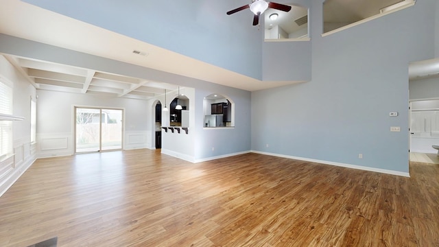 7315 San Vista Dr, Columbus, GA 31909 - unfurnished living room with arched walkways, ceiling fan, coffered ceiling, wood finished floors, and beamed ceiling