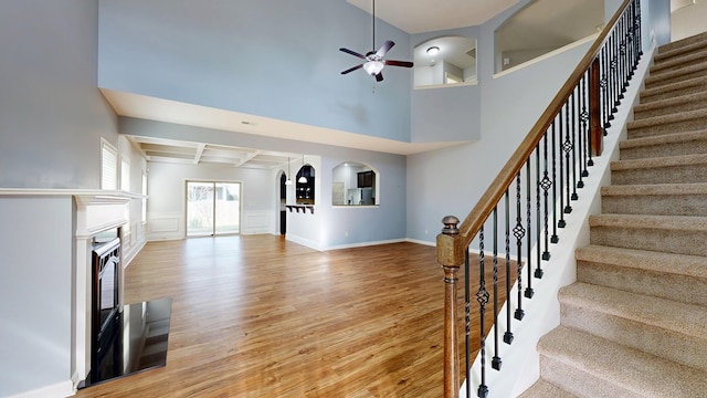7315 San Vista Dr, Columbus, GA 31909 - unfurnished living room featuring light wood-type flooring, a ceiling fan, a fireplace, arched walkways, and stairs