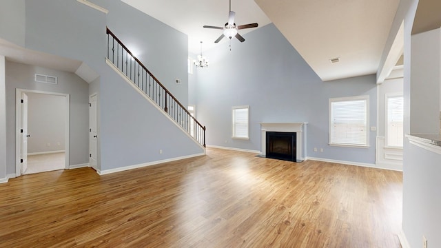 7315 San Vista Dr, Columbus, GA 31909 - unfurnished living room featuring a ceiling fan, a fireplace with flush hearth, plenty of natural light, wood finished floors, and high vaulted ceiling