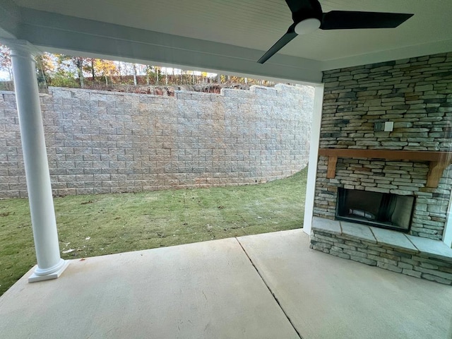 view of patio / terrace featuring ceiling fan and an outdoor stone fireplace