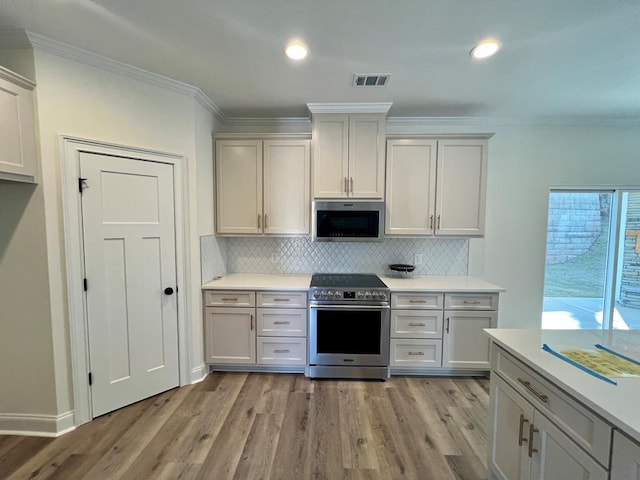 kitchen with white cabinetry, light hardwood / wood-style flooring, and stainless steel appliances