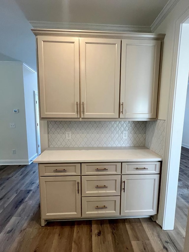 kitchen featuring tasteful backsplash, ornamental molding, and dark hardwood / wood-style floors