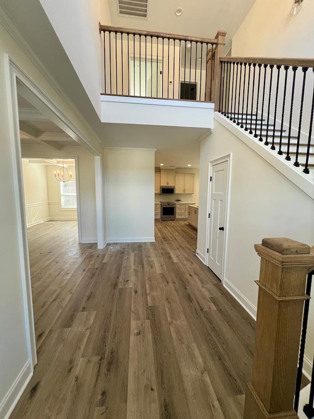 interior space with an inviting chandelier, a towering ceiling, and dark hardwood / wood-style flooring