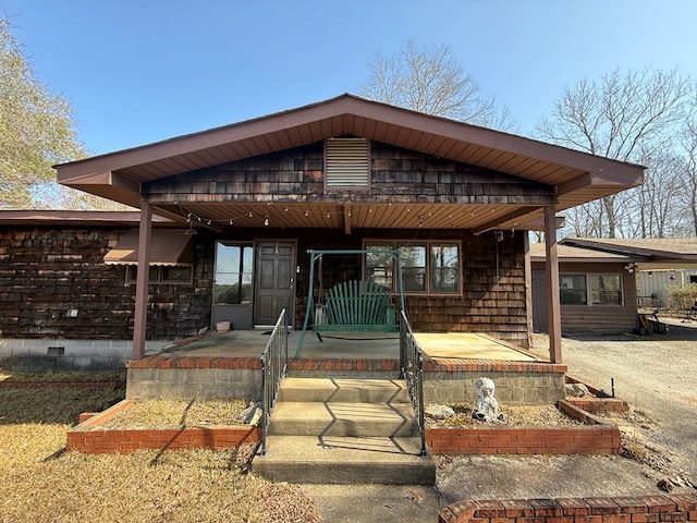 back of property featuring covered porch