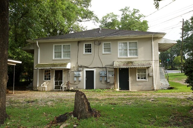 rear view of property with a lawn