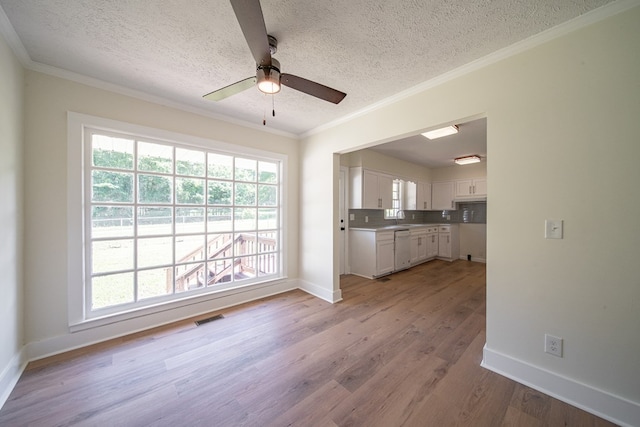 35 Dogwood St, West Point, GA 31833 - kitchen featuring dishwasher, a textured ceiling, white cabinets, baseboards, and light wood-style flooring