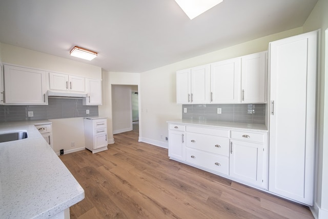 35 Dogwood St, West Point, GA 31833 - kitchen featuring decorative backsplash, white cabinets, and light wood-type flooring