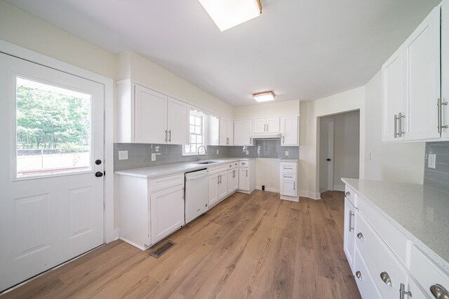 35 Dogwood St, West Point, GA 31833 - kitchen featuring white dishwasher, a sink, decorative backsplash, light wood finished floors, and white cabinets