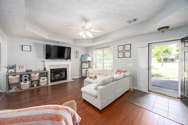 6 Lincolnshire Ln, Phenix City, AL 36870 - living room with a textured ceiling, a raised ceiling, dark wood-type flooring, a fireplace with flush hearth, and ceiling fan