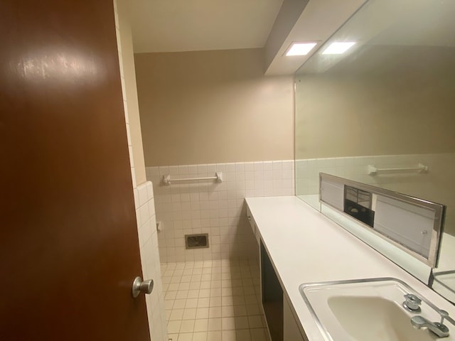 bathroom featuring vanity and tile walls