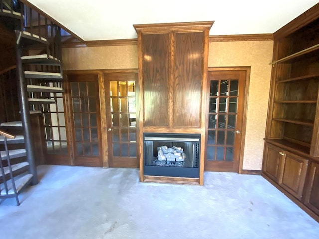 unfurnished living room with french doors, carpet floors, and ornamental molding