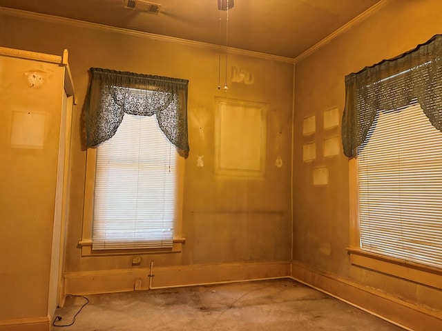 carpeted spare room featuring baseboards, ornamental molding, and visible vents