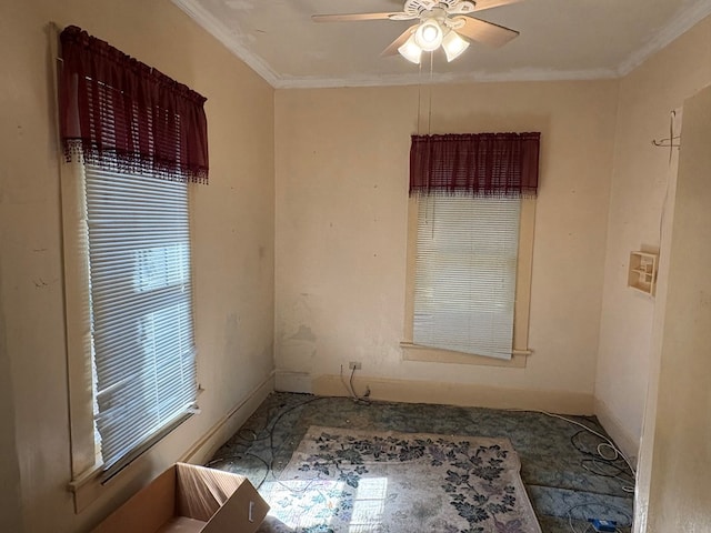 spare room featuring baseboards, ornamental molding, and a ceiling fan