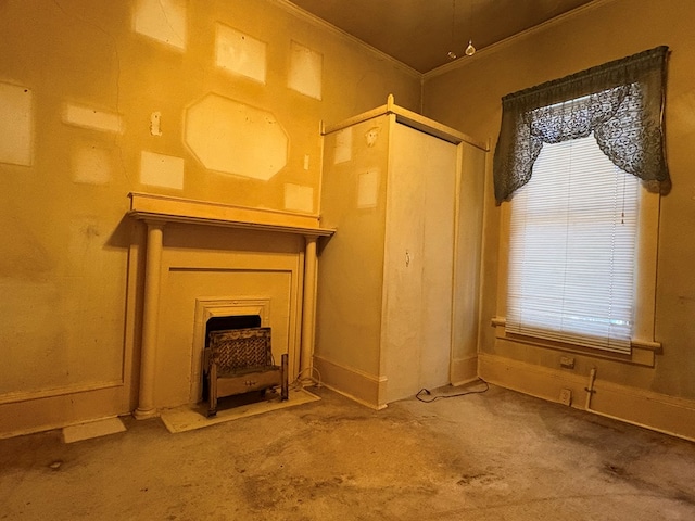 unfurnished living room with crown molding, baseboards, and plenty of natural light