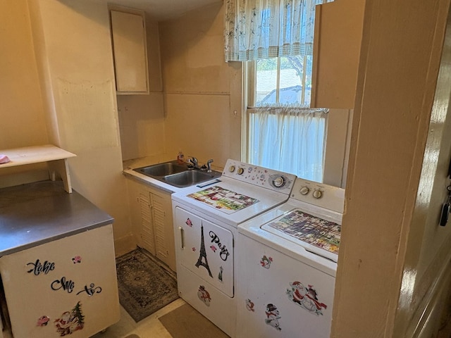 laundry room with cabinet space, washing machine and dryer, and a sink