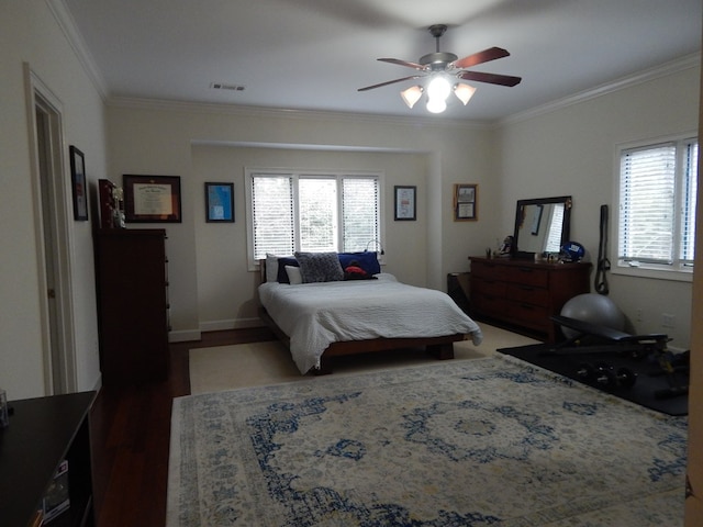 bedroom featuring baseboards, visible vents, wood finished floors, and ornamental molding