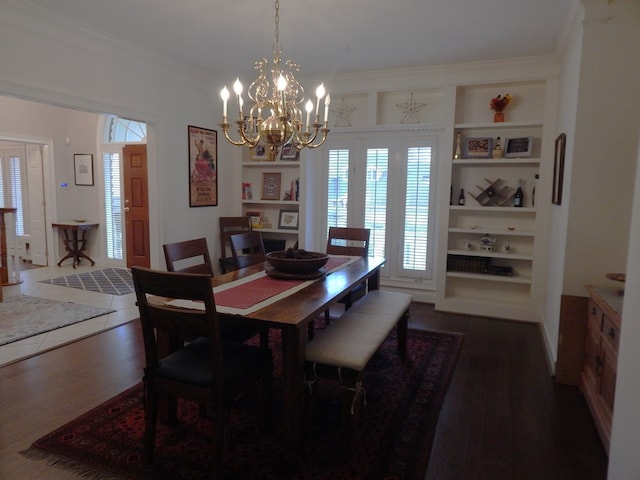 dining area featuring dark wood-style floors, built in shelves, a chandelier, and crown molding