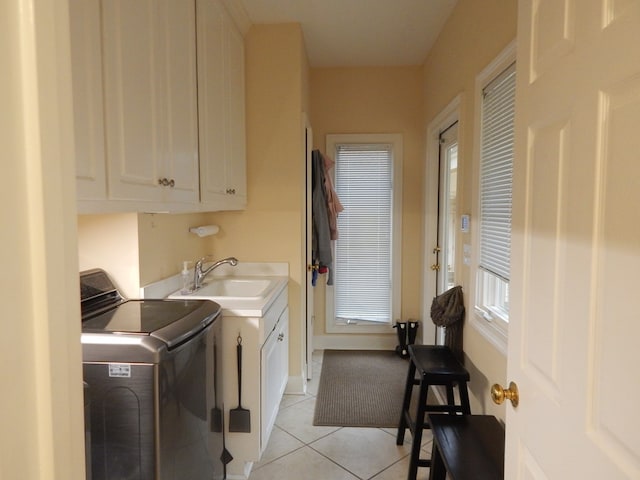 laundry area with light tile patterned floors, a sink, and cabinet space