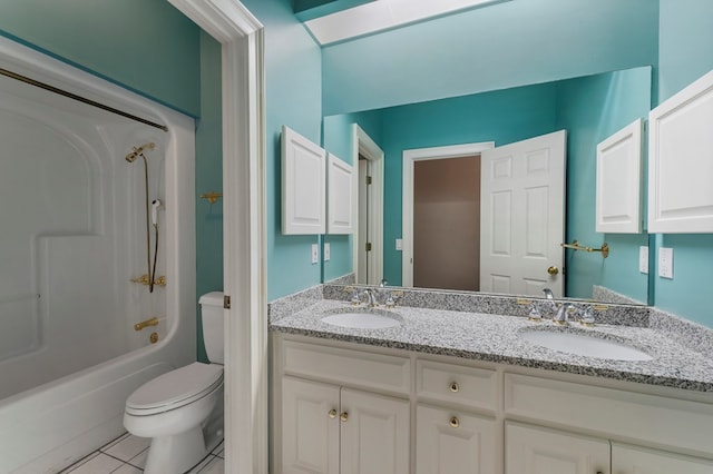 full bathroom featuring toilet, tile patterned flooring, double vanity, and a sink