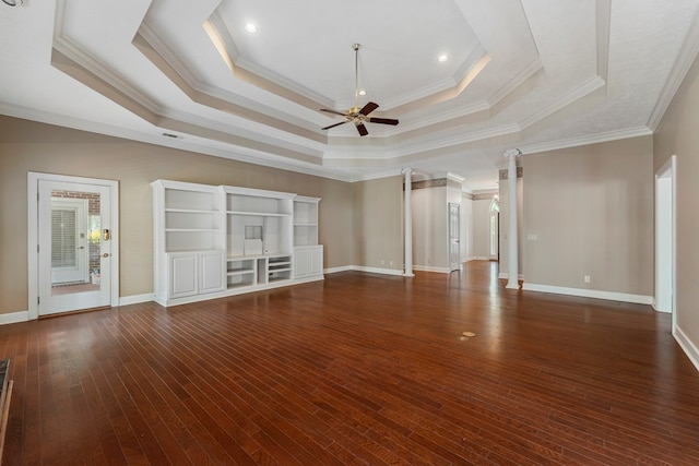 unfurnished living room featuring decorative columns, dark hardwood / wood-style flooring, ornamental molding, ceiling fan, and a raised ceiling